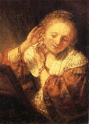 Young Woman Trying on Earrings Rembrandt